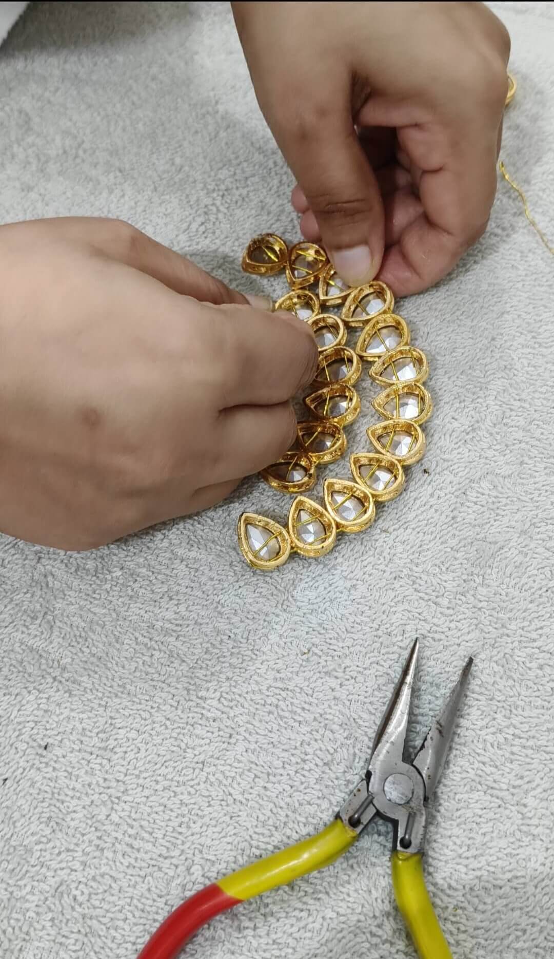 Attaching white big tilak shape kundan with wire